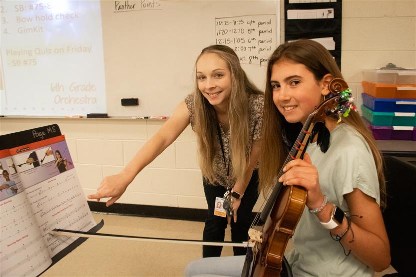 A girl smiles in an orchestra class